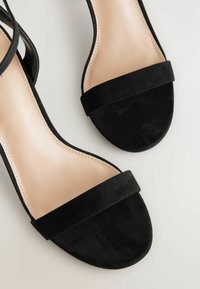 Sandales en daim noir avec une large sangle avant, un design à bout ouvert et une semelle intérieure nude lisse avec de subtils détails de couture.