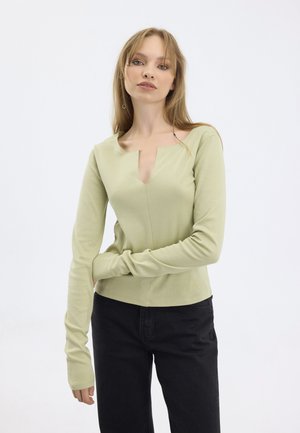 Light green long-sleeve top with a wide scoop neckline and a center cutout detail; features snug fit and soft texture with elongated sleeves.