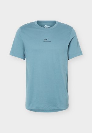 Ανοιχτό μπλε κοντομάνικο μπλουζάκι Nike Pro με στρογγυλή λαιμόκοψη, με μαύρο λογότυπο στο κέντρο του στήθους σε απλό φόντο.