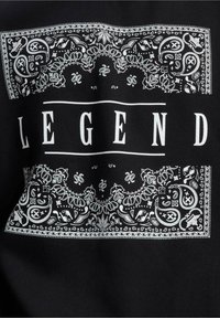 Black fabric with a white paisley bandana design. Central text reads "LEGEND" in bold white letters, framed above and below.