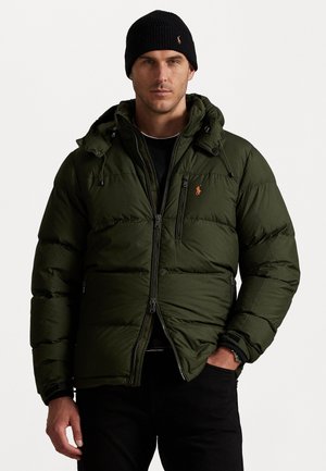Groene donzen jas met een ritssluiting aan de voorkant, verstelbare capuchon en geborduurd logo. Draag het over een zwart langemouwen shirt en in combinatie met donkere broeken.