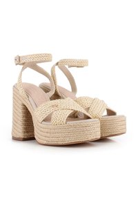 Sandalias de plataforma trenzadas en beige con una correa en el tobillo, que presentan un tacón grueso de tejido y un forro interior suave para mayor comodidad.