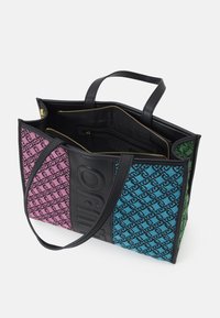 Grote tote bag met panelen van stof in een roze, blauwe en groene print, met een zwart logoaccent. Gladde leren handvaten en gouden ritsen.