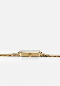 Montre rectangulaire en or avec un cadran lisse et couronne visible. Bracelet en maille avec un motif en maillons. Verre transparent, design minimaliste.