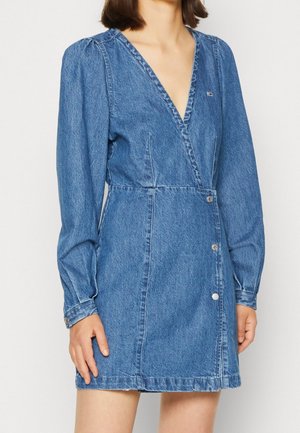 Denimkjole med dyb V-hals, lange ballonærmer, indsnævret talje og frontknaplukning i en medium blå vask.