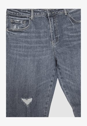 Vaqueros de mezclilla gris con un pequeño agujero triangular rasgado en el muslo izquierdo, con bolsillos delanteros y cintura abotonada.