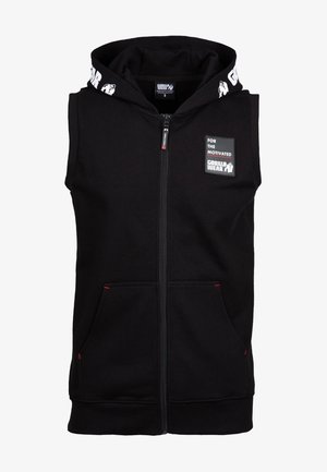 Musta hihaton huppari, jossa edessä vetoketju, kengurun taskut ja rinnassa "For the Motivated Gorilla Wear" -merkki. Hupun reunassa teksti Gorilla Wear.