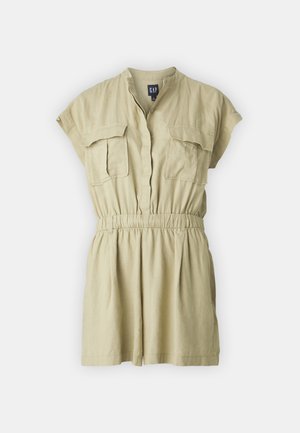 Kratka, lahka kombinezonska obleka v bež barvi z kratkimi rokavi, dvema sprednjima žepoma in elastičnim pasom za udobno prileganje.