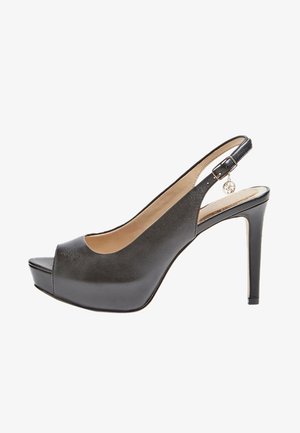 Musta nahkainen slingback-korkokenkä avoimella varpaalla, platform-etuosalla ja metalliriipuksella remmissä. Sileä pinta ja tyylikäs muotoilu.