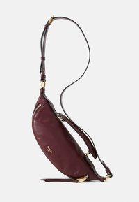 Sac à main en cuir bordeaux de forme croissant, avec des accents en métal doré et une bandoulière grise détachable. Fermeture éclair.