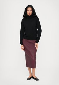Pull en col roulé noir, conception ajustée. Jupe crayon en cuir bordeaux, texture lisse, longueur au genou. Des ballerines noires complètent la tenue.