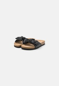 Sorte sandaler med knyttede faux skinnremmer, kork såle og gummisåle. Glatt tekstur og enkelt, flatt design.