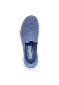 Zapato slip-on de malla azul con plantilla de espuma y suela de goma blanca, con una superficie texturizada y detalle del logo en la plantilla.