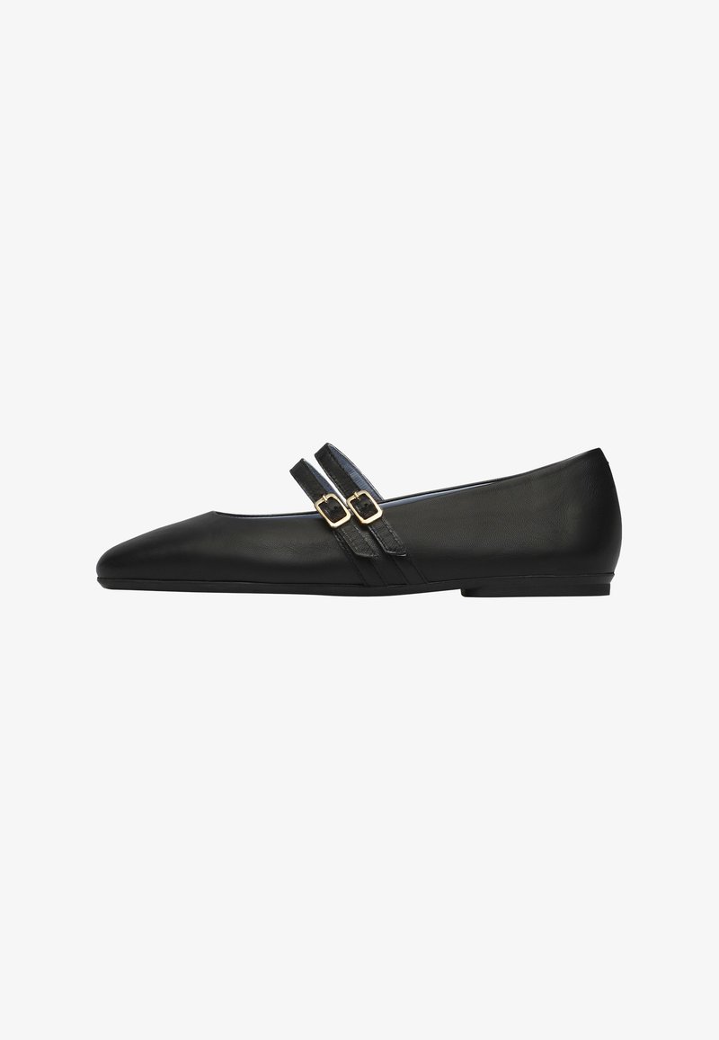 Chaussure plate en cuir noir avec bout pointu et deux fines lanières avec boucles dorées sur le cou-de-pied, vue de profil sur fond blanc.