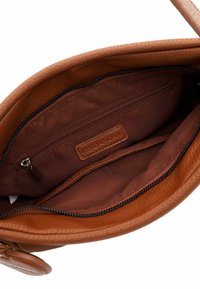 Interno di una borsa a tracolla in pelle marrone con finitura strutturata, tasca con cerniera e fodera in tessuto morbido. Colore: marrone intenso con accenti delicati.