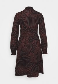 Långärmad klänning i svart och bordeaux med ett vågigt mönster, figursydd midja, volangkrage och smockade ärmslut. Texturerat tyg.