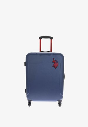 Valise rigide bleue avec poignée télescopique rouge, quatre roues et un petit motif rouge de Spiderman dans le coin avant supérieur.