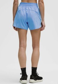 Gaiši zili sporta šorti ar elastīgu jostu, kuros ir divas sānu kabatas un gluda, viegla tekstūra.