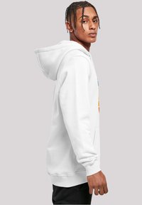 White fleece hoodie with a front pocket, drawstring hood, and ribbed cuffs. Features colorful printed text on the front. Simple design.