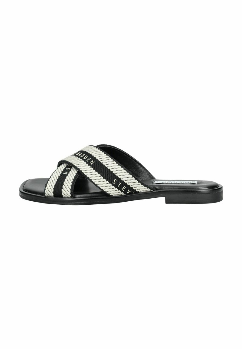 Mule à bande noire et blanche avec des sangles en tissu tissé et une semelle en cuir lisse. Caractérisé par une semelle plate à profil bas.
