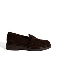 Brauner Wildleder-Loafer mit runder Zehenform, dekorativen Metallakzenten und einer dicken, strukturierten Sohle. Einfaches Design, niedriges Profil.