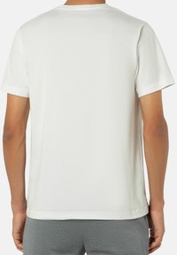 Weiße Baumwoll-T-Shirt mit kurzen Ärmeln und rundem Ausschnitt. Das Design ist schlicht und hat einen einfarbigen Rücken ohne Muster oder Akzente.