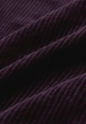 Lila Cordstoff mit vertikalen Rillen, weicher Textur und dezentem Glanz, der die Tiefe und Dimensionalität des Materials hervorhebt.