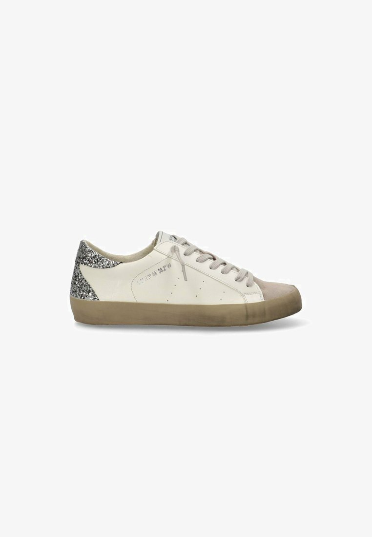 Zapatilla de piel blanca con una puntera de ante gris y un talón plateado brillante. Presenta costuras en tono y cordones redondos. Suela de goma.