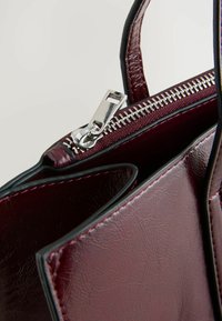 Marlboro rote Handtasche aus Kunstleder mit silbernem Reißverschluss, kontrastierender schwarzer Besatz, strukturierter Form und sichtbaren Nähten.