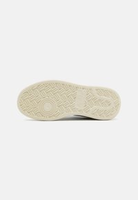 Suola di sneaker bianca con un design in gomma testurizzata caratterizzato da motivi circolari e rettangolari, completata da una suola di colore crema.