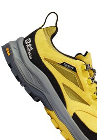 Scarpa da trekking Jack Wolfskin gialla e nera con suola testurizzata, pannelli in tessuto Texapore e fibbia sul tallone.