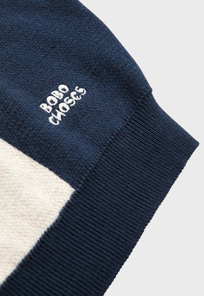 Suéter de punto marino con panel beige en contraste. Presenta puños acanalados y el logotipo bordado "BOBO CHOSES" en hilo blanco. Textura suave.