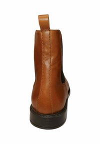 Botín de cuero marrón hasta el tobillo con un acabado suave, paneles laterales elásticos y una lengüeta en la parte trasera. Suela de goma negra resistente.