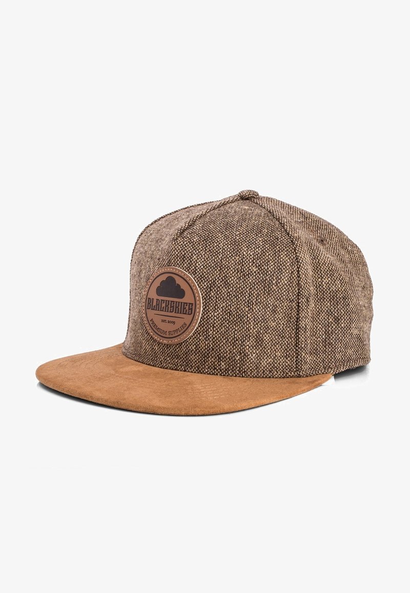 Brown fabric snapback cap with a suede brim. Features a circular leather patch labeled "BLACKSKIES" and a textured woven pattern.