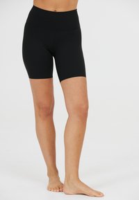 Sort højtaljede cykelshorts lavet af strækbart stof. Har en glat tekstur og er i mid-thigh længde. Ingen synlige logoer eller mønstre.