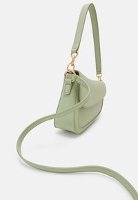 Borsa a spalla in pelle verde chiaro con patta curva e lunga tracolla, dotata di anelli in metallo dorato su fondo bianco.