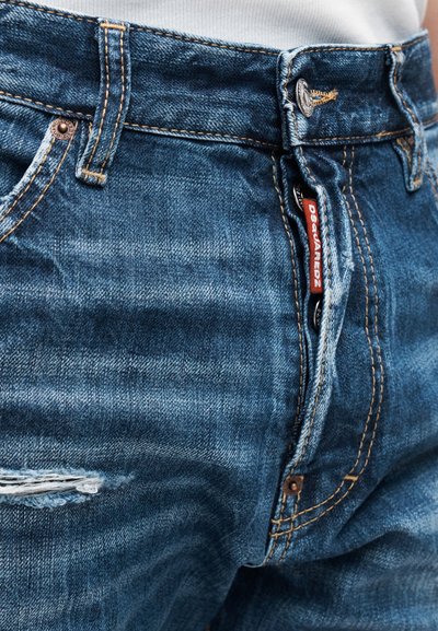 Τζιν παντελόνια από μεσαία μπλε ύφανση, με διακριτική φθορά, χαλκοχρωμικά εξαρτήματα και αντίθετο κίτρινο ράψιμο. Εμφανές ετικέτα.