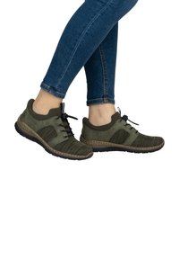 Baskets de sport vertes avec des matériaux en maille et en daim, bout rond, design texturé, lacets noirs et semelle rembourrée.