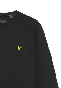 Maglietta nera a maniche lunghe con un logo di un uccello giallo ricamato sul lato sinistro del petto e colletto tondo.