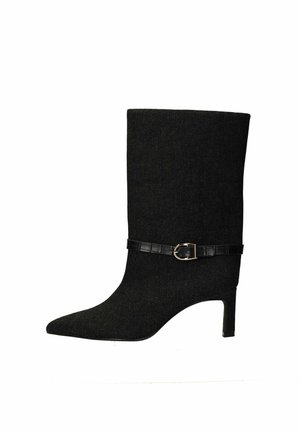Bottes de cheville en tissu noir avec un bout pointu, une forme effilée et un talon de hauteur intermédiaire. Présente une ceinture en cuir noir avec une boucle en métal doré.
