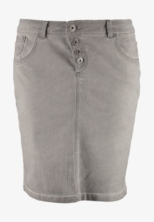 Femme portant un haut noir à manches longues, une jupe grise boutonnée devant, des collants noirs, des bottines et un sac bandoulière noir.