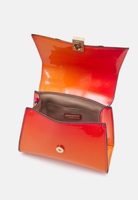 Oranssi liukuvärillinen käsilaukku, jossa kiiltävä pinta. Varustettu kultaisella napsautussulkimella ja ruskealla sisäpuolella, jossa pieni tasku.