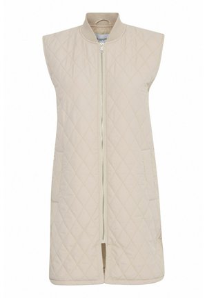 Gilet sans manches beige matelassé avec un col haut, fermeture éclair avant et deux poches latérales, présentant une texture lisse et un motif en diamant.