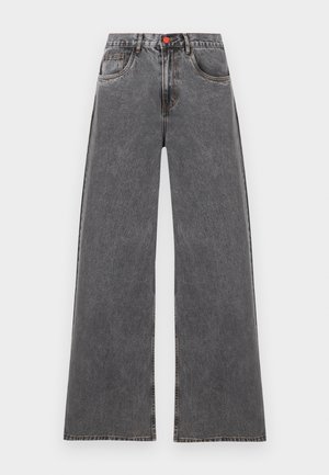 Jean en denim gris taille haute à jambes larges, avec poches avant et fermeture par bouton rouge, présenté à plat sur un fond blanc.