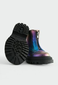 Stivali alla caviglia metallici con una finitura iridescente colorata, dotati di una cerniera laterale, suola in gomma nera chunky e battistrada testurizzato.