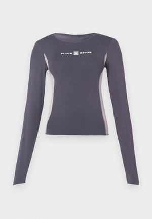 Mørkegrå langermet tettsittende treningsgenser med lysegrå sidepaneler og hvit "Nike Shox"-logo på brystet.