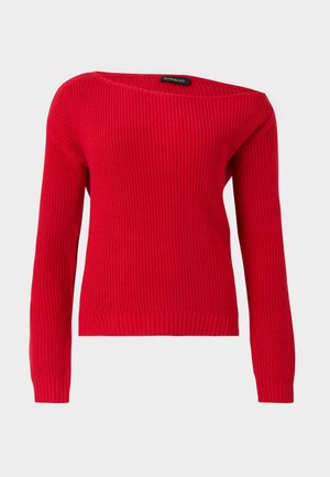 Punane soonikkoes kampsun pikkade varrukatega ja lai, asümmeetriline paadikaelusega helehallil taustal.