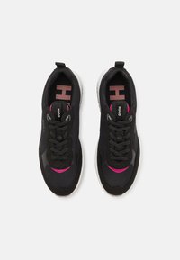 Black mesh sneakers with pink accents, featuring round laces, a cushioned sole, and a pull tab on the heel. Branding on the tongue and sides.