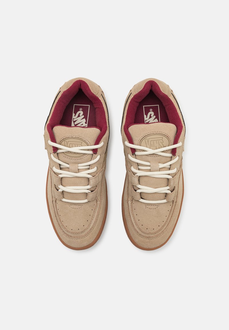 Sneaker in suede beige con lacci bianchi, rivestimento bordeaux e suola in gomma color tan. Presentano perforazioni per la ventilazione e dettagli di marca.