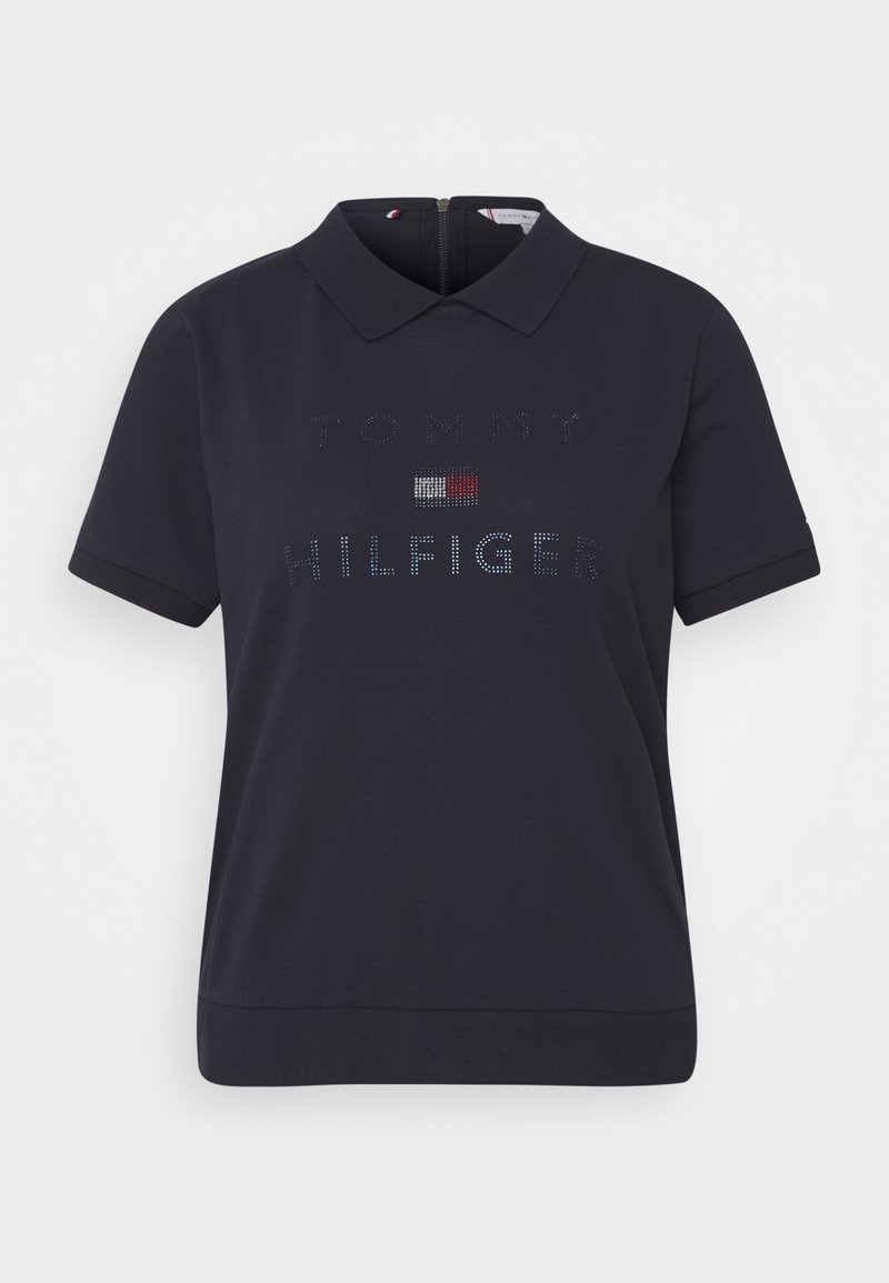 Laivaston lyhythihainen polo-paita, jossa on kaulus, resorihihat ja edessä kimalteleva logo suunnittelu, jossa on pieni lippuakkentti.